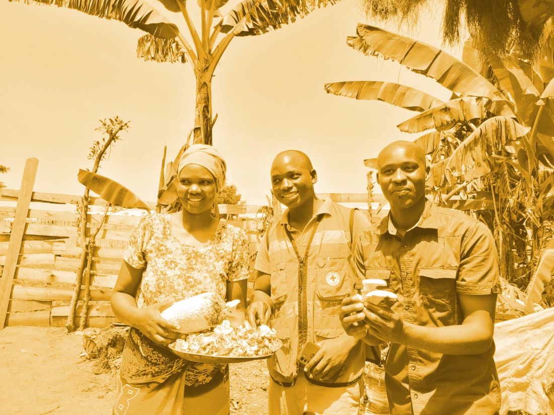 three refugees presenting their mushroom harvest from regenerative agriculture